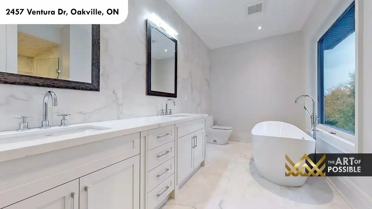 Primary ensuite with full marble walls dual vanity freestanding soaker tub and chrome cross-handle fixtures at 2457 Ventura Dr Oakville