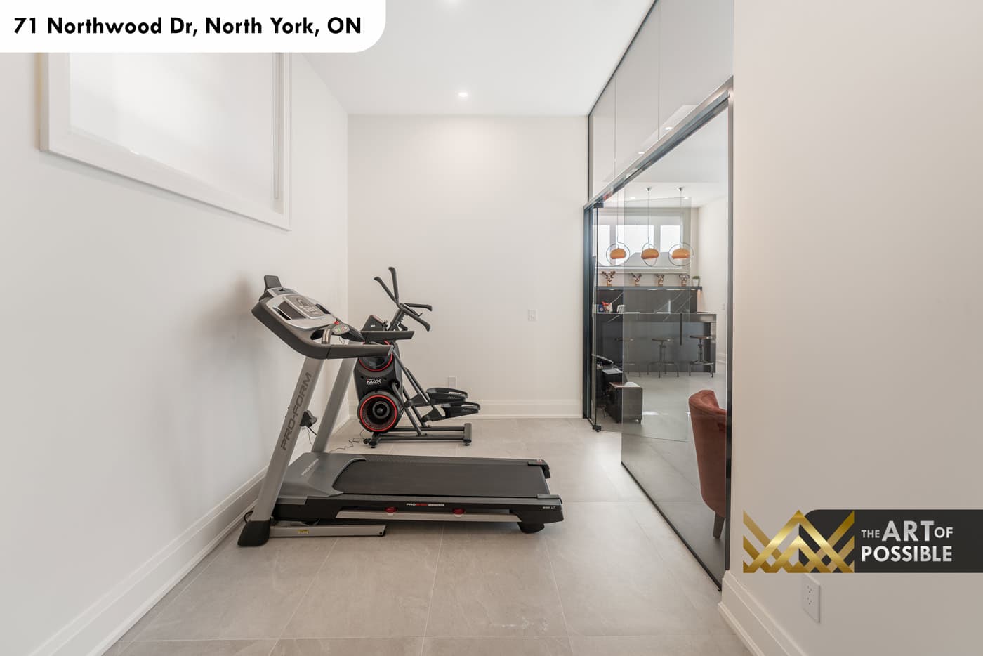 Home gym with treadmill and elliptical behind frameless glass partition doors