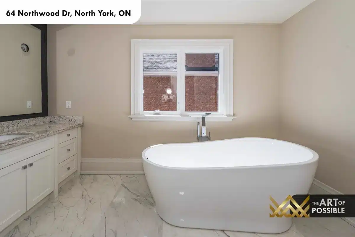 Freestanding soaker tub and marble tile floor in primary ensuite