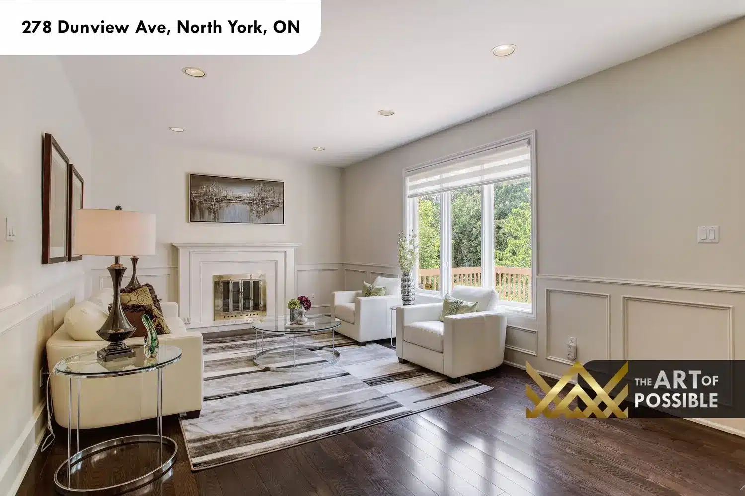 Family room with wainscoting, white fireplace surround with brass screen and rear windows