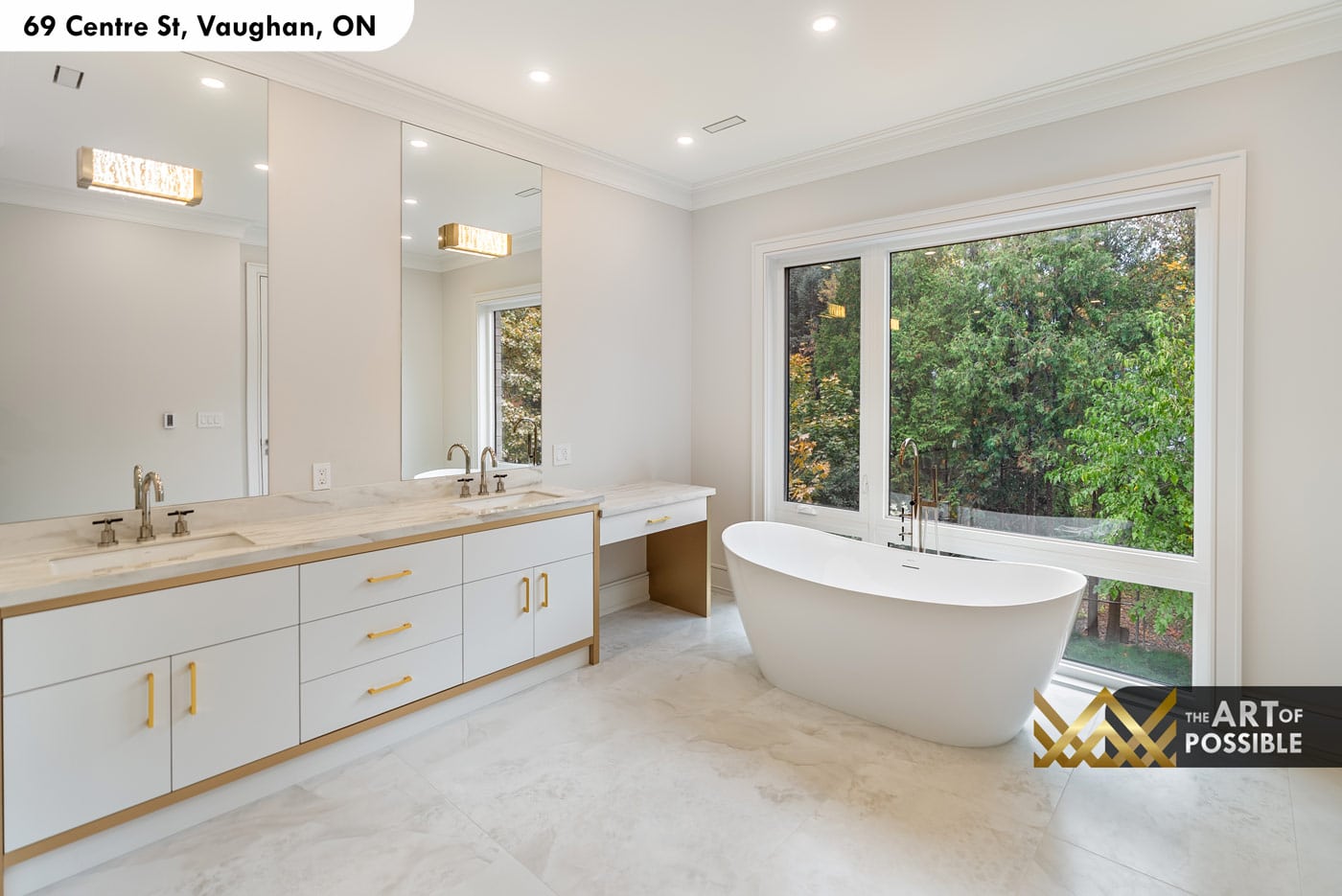 Primary ensuite with white double vanity, freestanding soaker tub and tree-view window