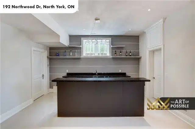 Lower level wet bar with dark countertop and floating shelves, 192 Northwood Dr