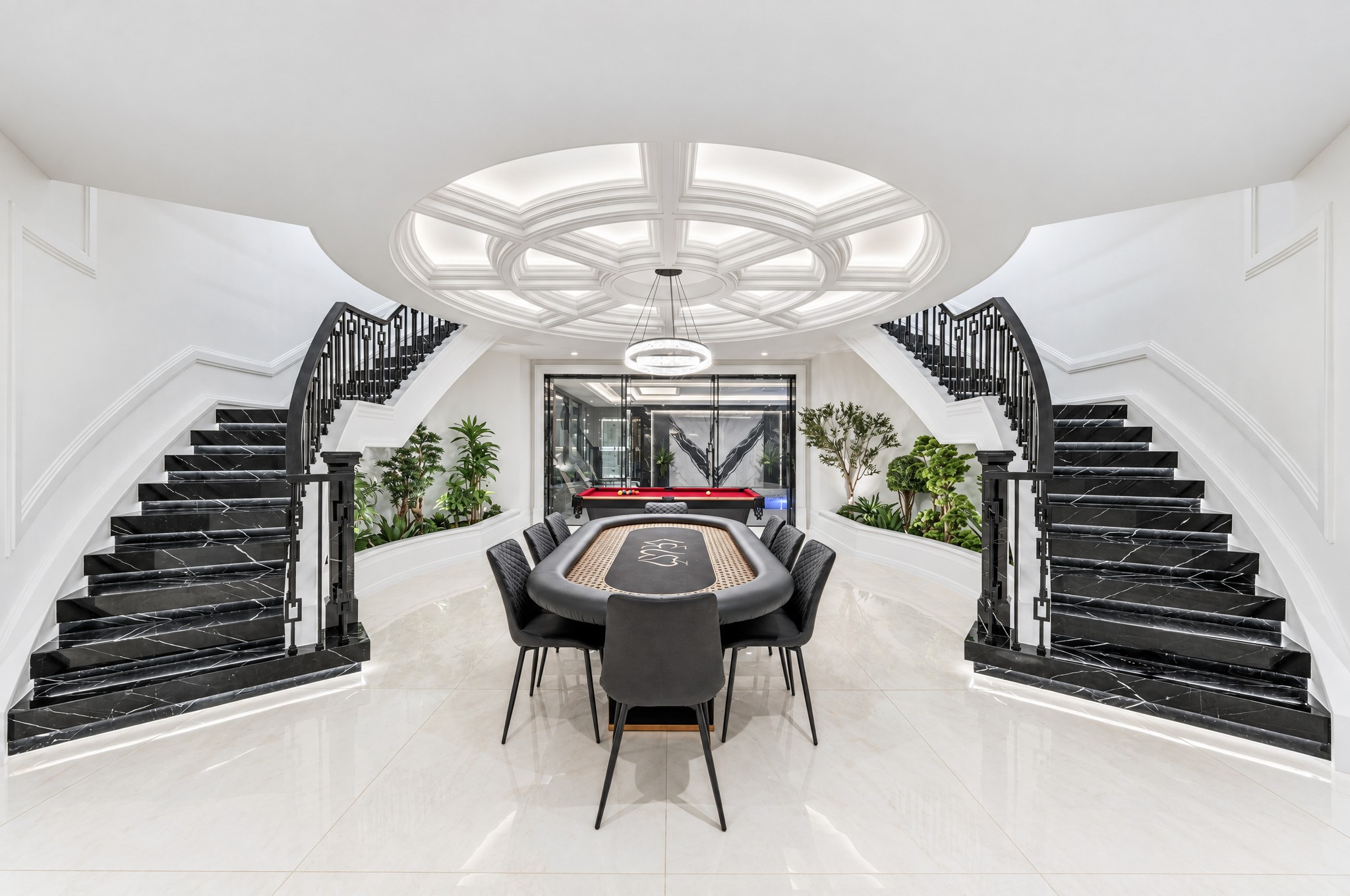 Lower level twin black marble staircases with circular coffered ceiling and games area