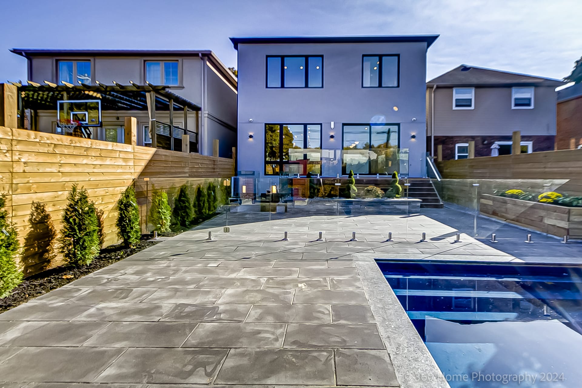 Rear yard at 100 Glenvale Blvd with in-ground pool, frameless glass fence and large-format stone patio