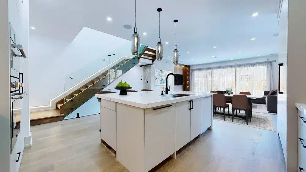 Kitchen island with Calacatta quartz waterfall and glass pendants at 82 Hanna Rd