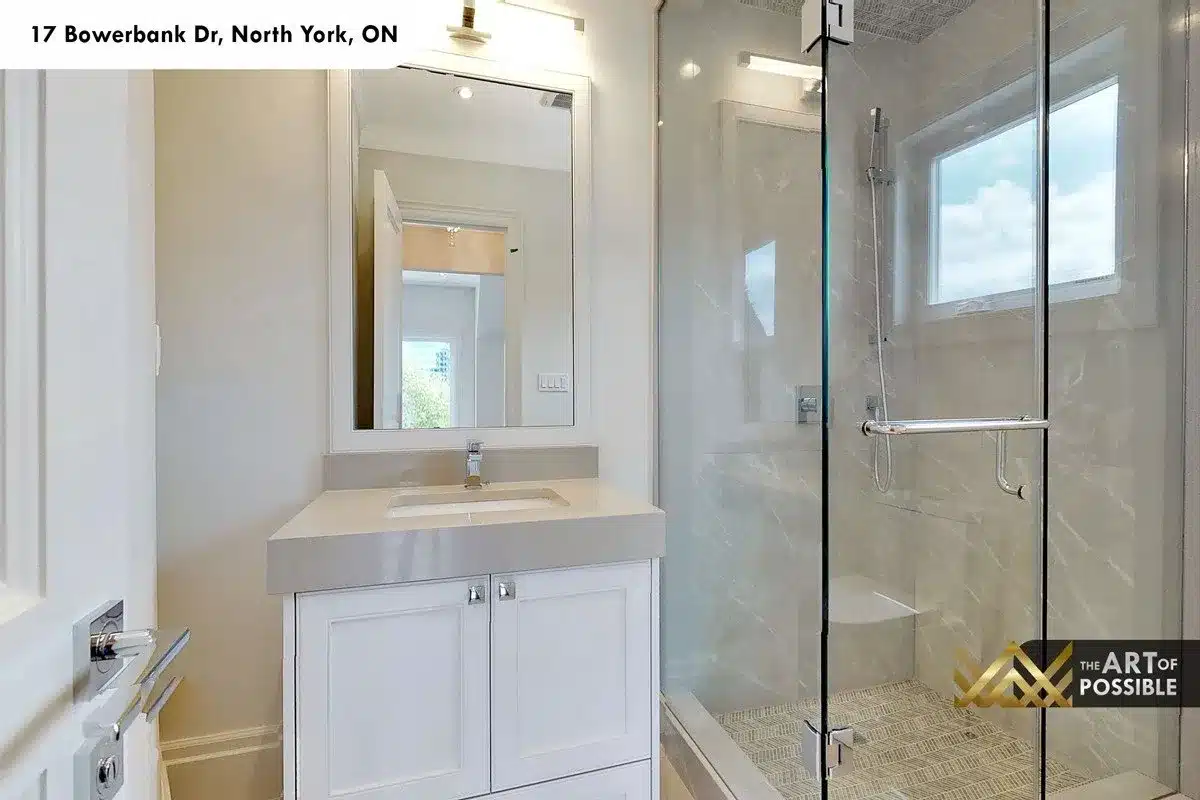 Secondary bathroom with glass shower enclosure and white vanity