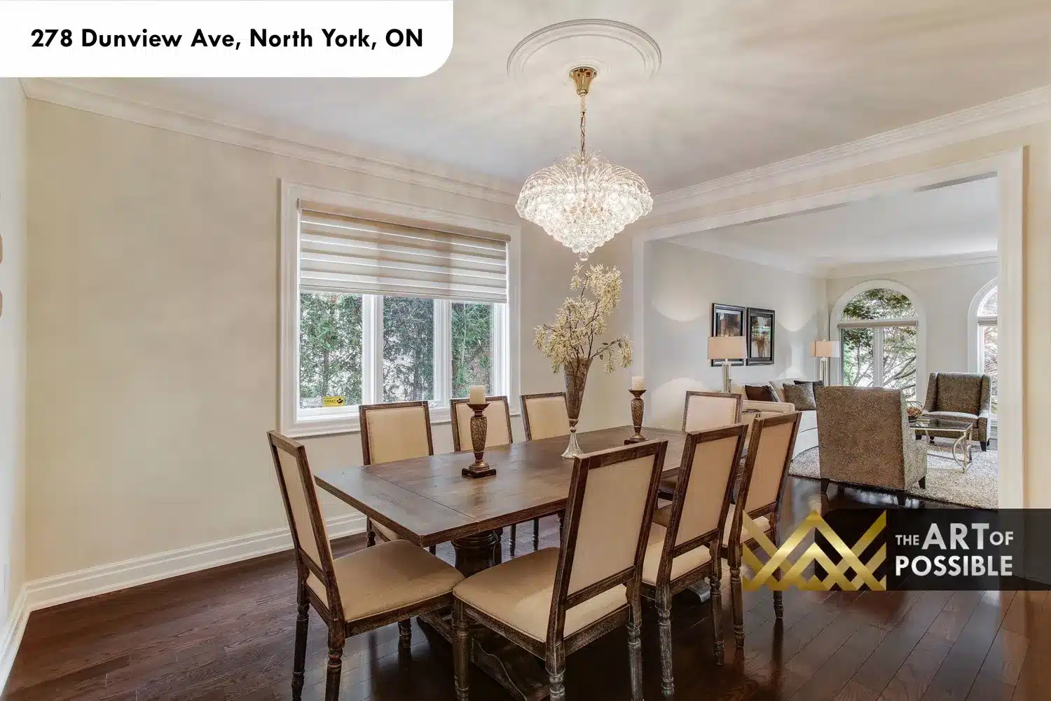 Dining room with ten-seat table looking through to the formal living room and arched windows