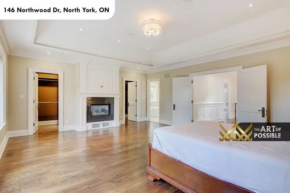 Primary bedroom showing his and hers walk-in closets and tray ceiling