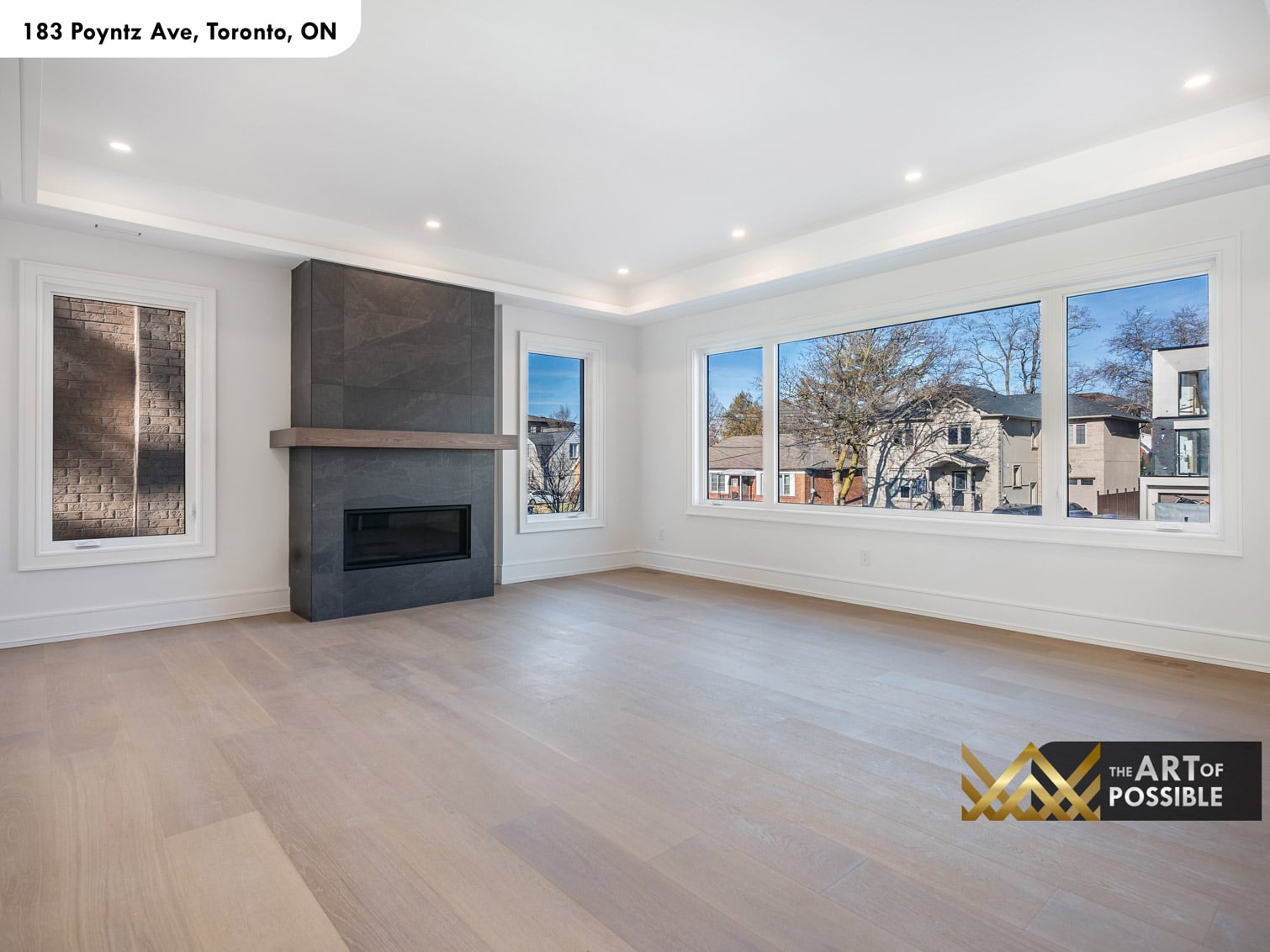 183 Poyntz Ave North York living room with full-height dark tile fireplace oak floating mantel and picture windows