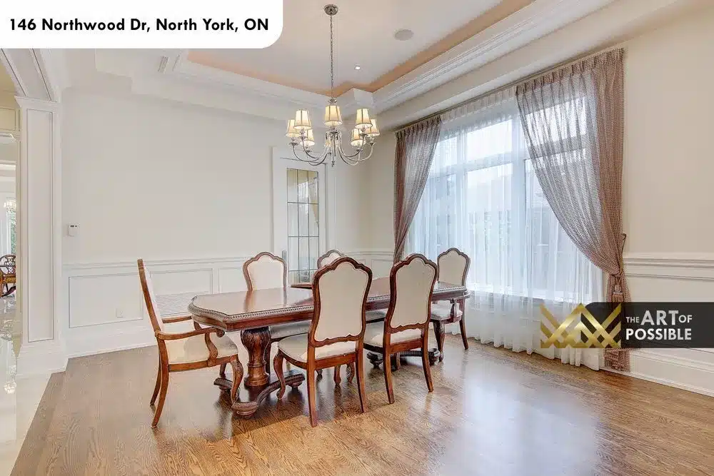 Formal dining room with crystal chandelier, wainscoting and large draped window