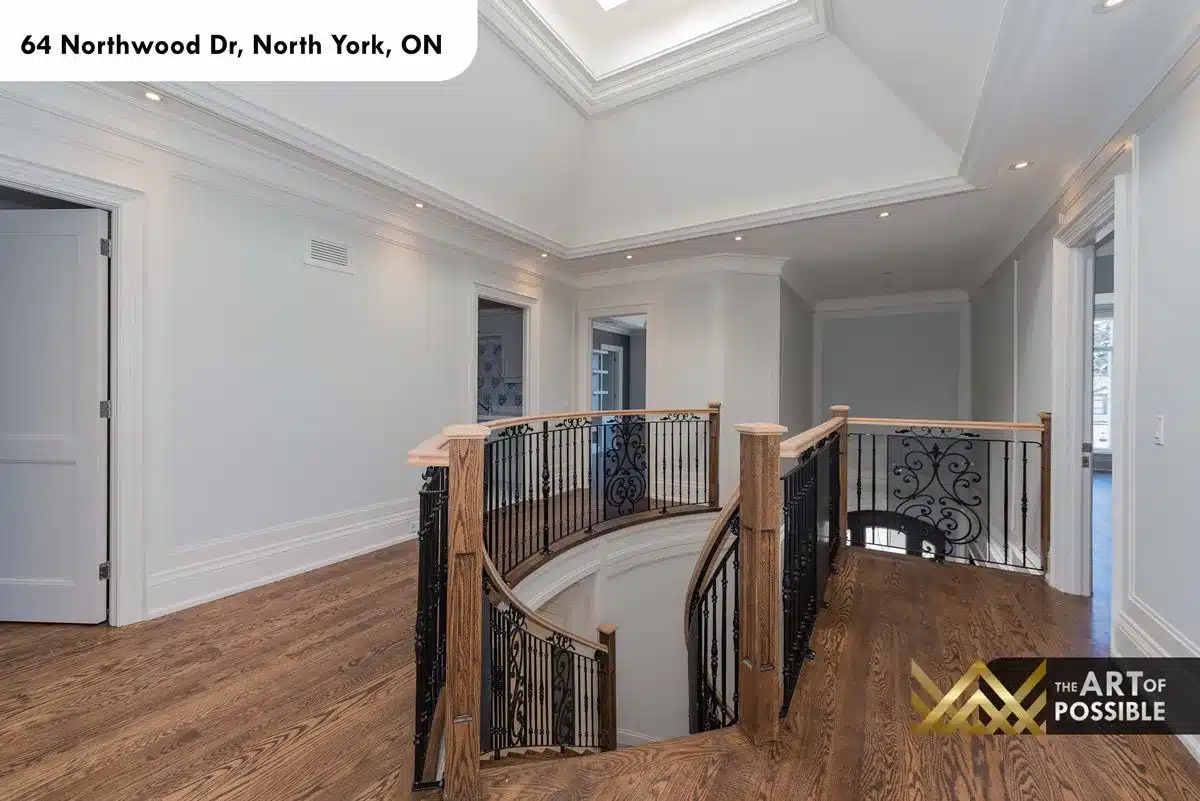 Upper floor landing with iron scrollwork railing and skylit staircase