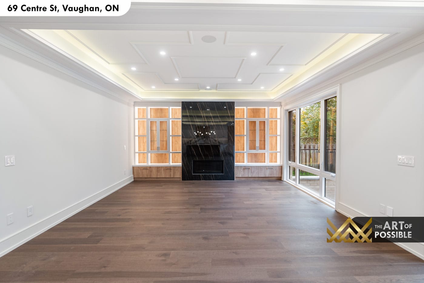 Family room with full-width walnut built-ins and full-height black marble fireplace surround