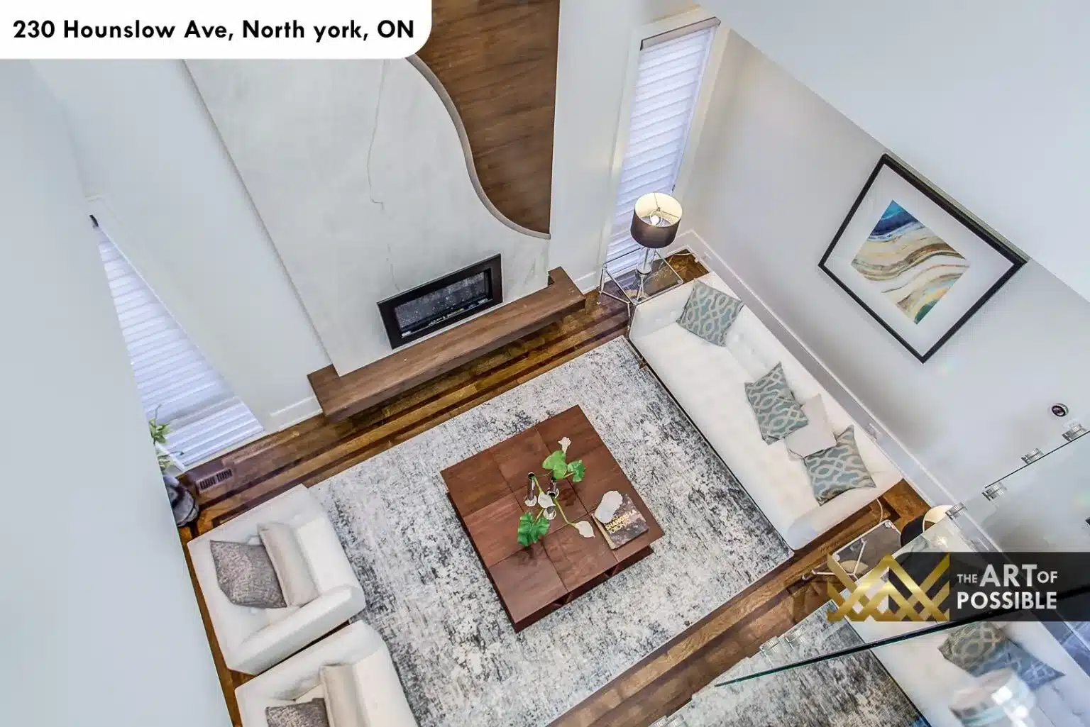 Aerial overview of the formal living room showing glass railings and the walnut fireplace surround