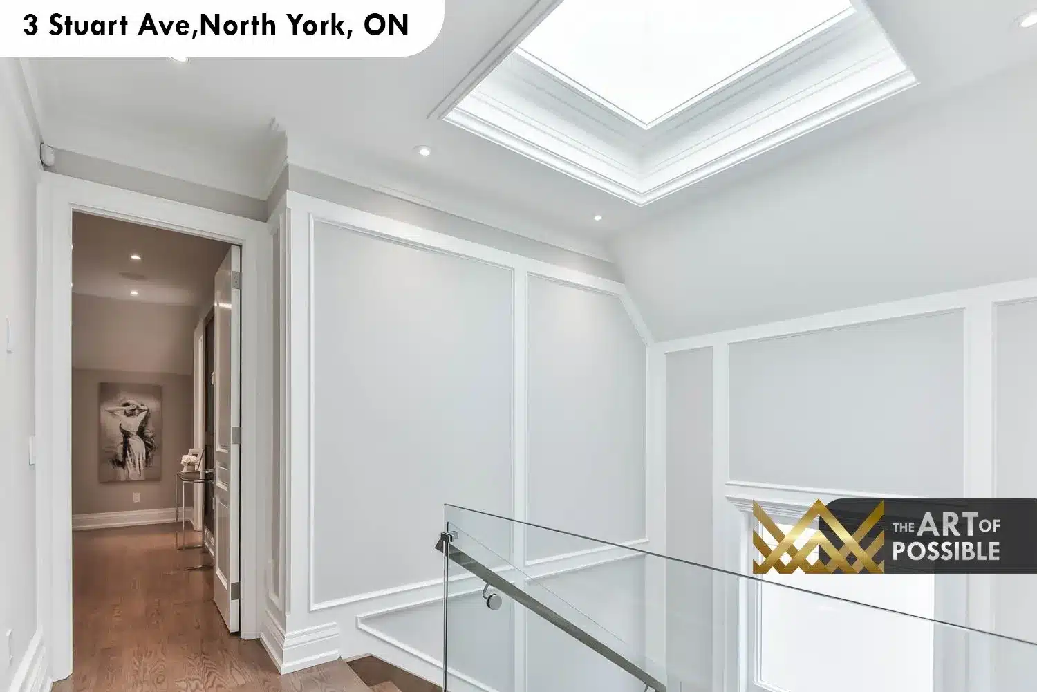 Upper landing with large square skylight and plaster crown surround above the glass-railed staircase