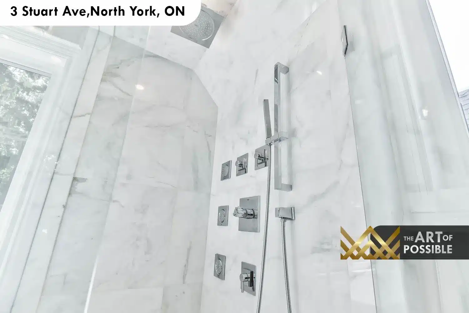 Close-up of marble shower walls with chrome body jets, hand shower and rain head