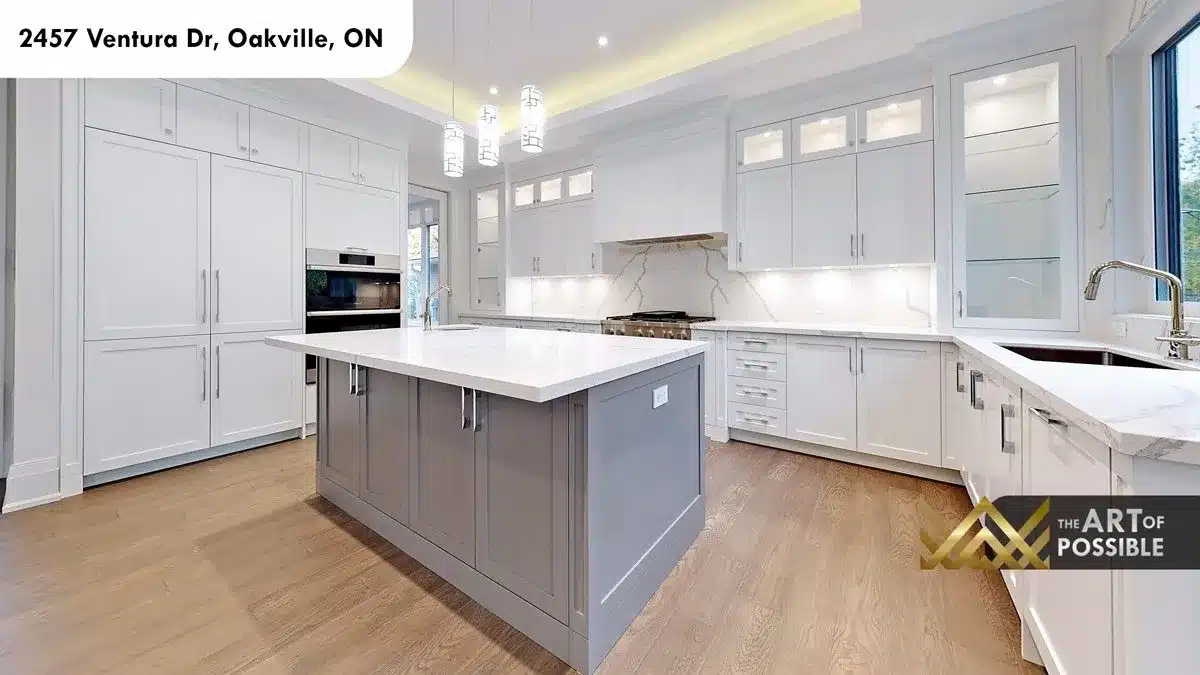 Kitchen island detail with white quartz countertop grey shaker cabinetry and marble backsplash