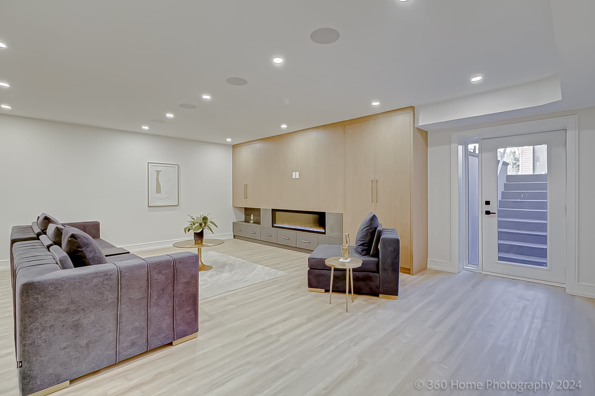 Lower level recreation room with oak millwork fireplace wall and walkout at 100 Glenvale Blvd