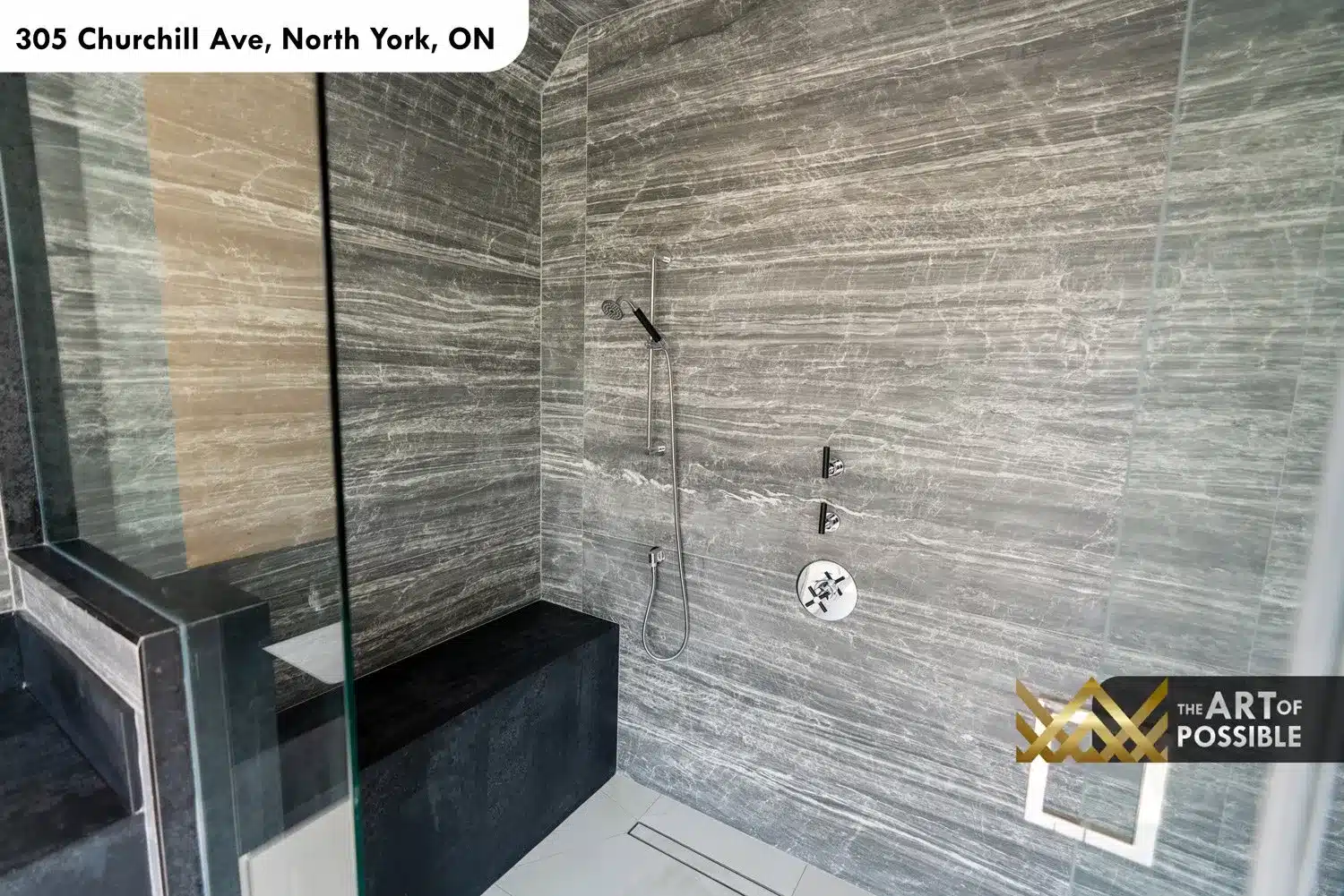 Primary ensuite shower interior with dark striated marble slab panels and chrome thermostatic shower controls