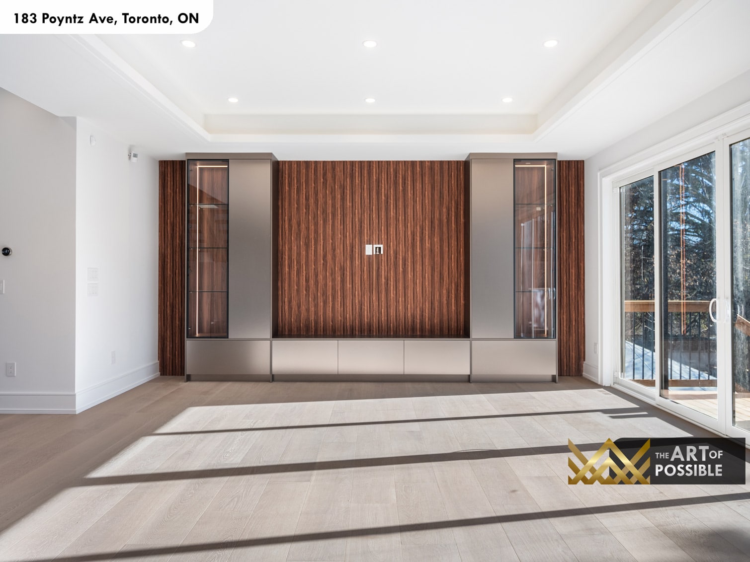 183 Poyntz Ave North York family room walnut slatted accent wall with built-in smoked glass display cabinets and sliding glass door to rear deck