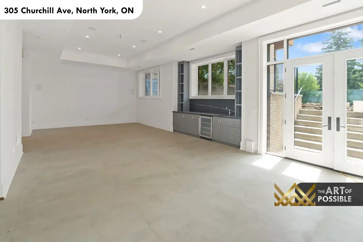 Lower level walk-out recreation room with wet bar, beverage fridge and French doors to backyard stairs