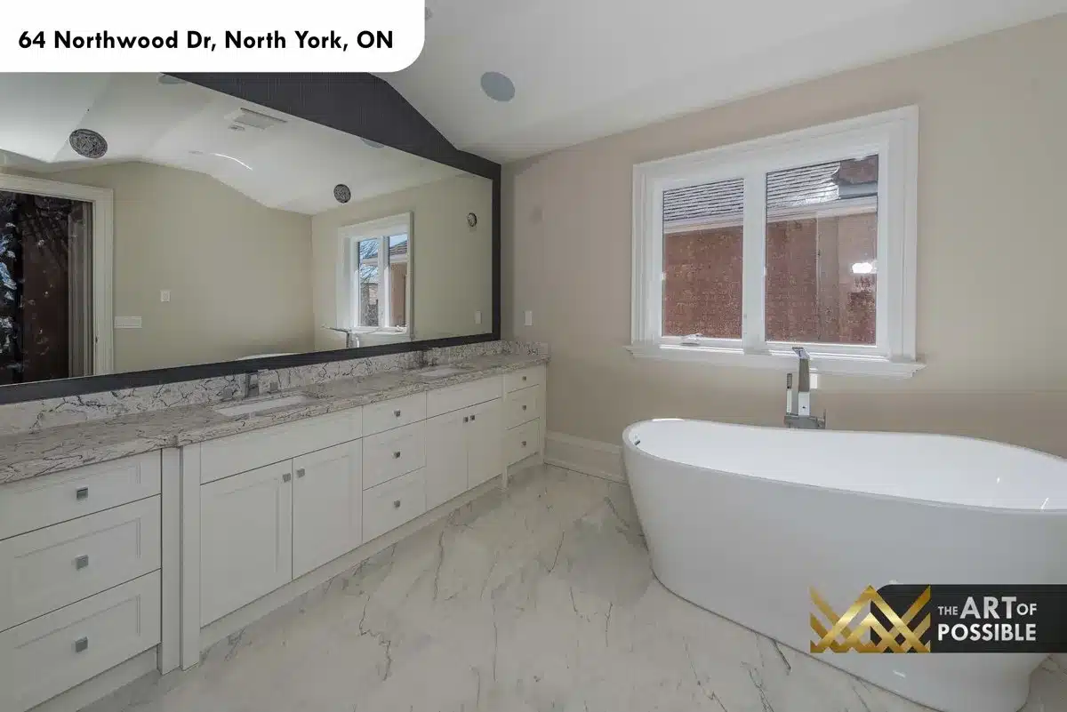 Primary ensuite with double vanity, marble floors and freestanding soaker tub