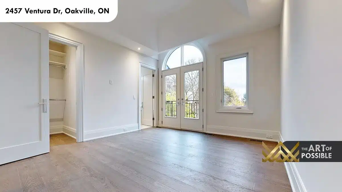 Secondary bedroom with arched French doors Juliet balcony and walk-in closet at 2457 Ventura Dr Oakville