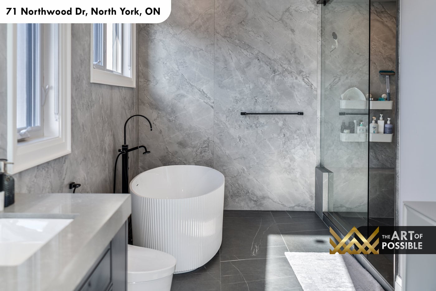 Primary ensuite with round white fluted freestanding soaker tub and frameless glass walk-in shower