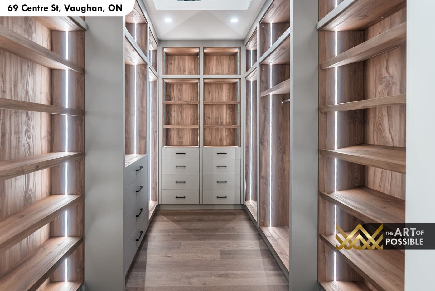 Primary walk-in closet with walnut veneer backing panels and vertical LED strip lighting