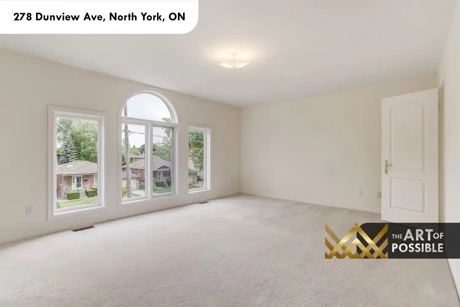 Secondary bedroom with arched window and carpeted floor