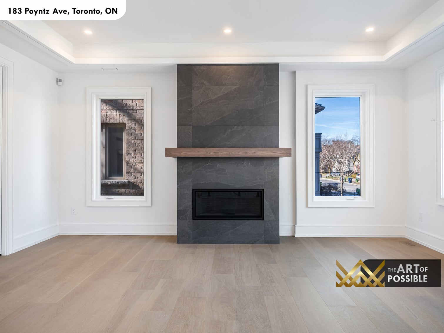 183 Poyntz Ave North York living room showing the charcoal tile fireplace surround with oak shelf mantel and tray ceiling