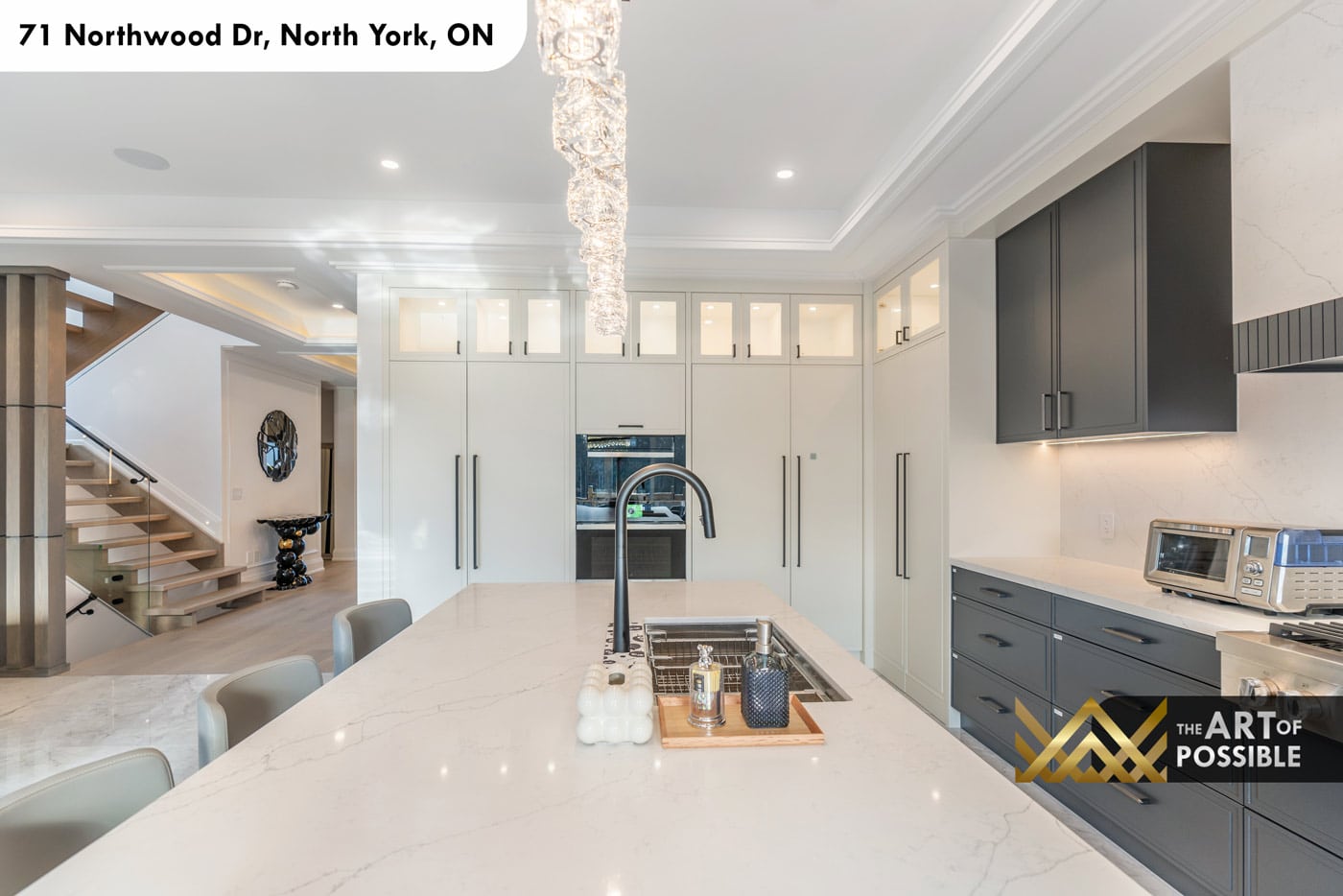 Kitchen island with matte black sink and faucet, white flat-front upper cabinetry and oven column