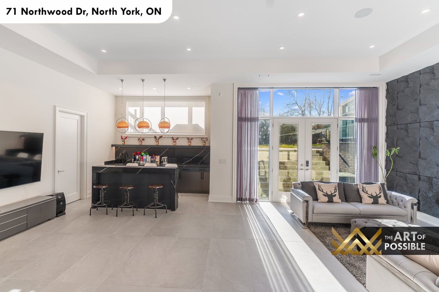 Basement rec room with rough-cut stone feature wall, TV wall and walkout to rear yard