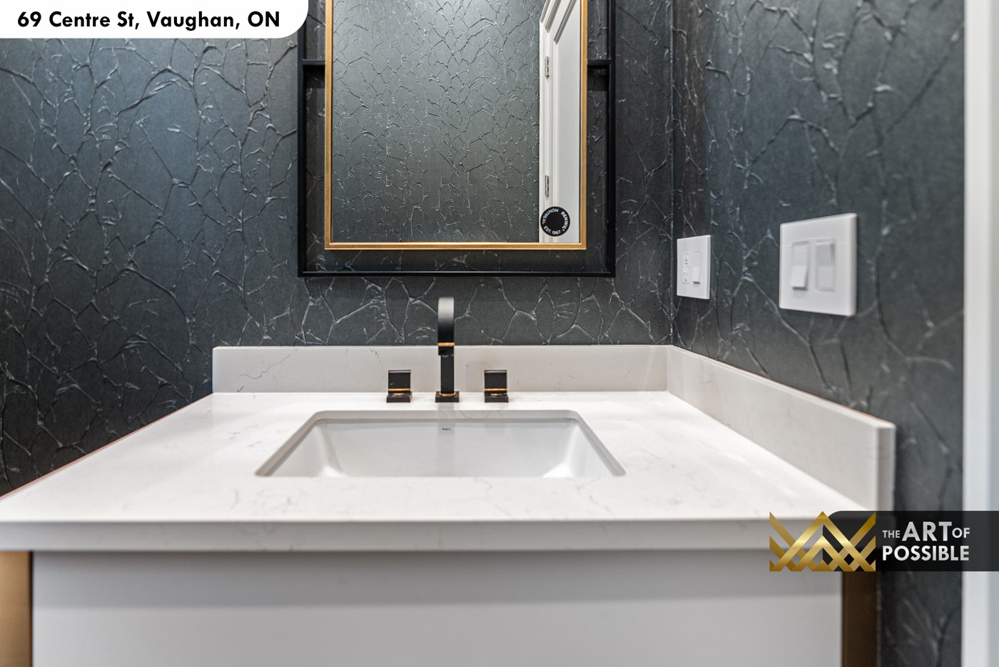 Main floor powder room with dark charcoal crackle wallpaper and gold-framed mirror