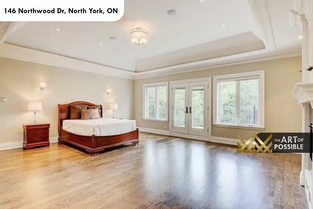 Primary bedroom with French doors to balcony and panelled gas fireplace