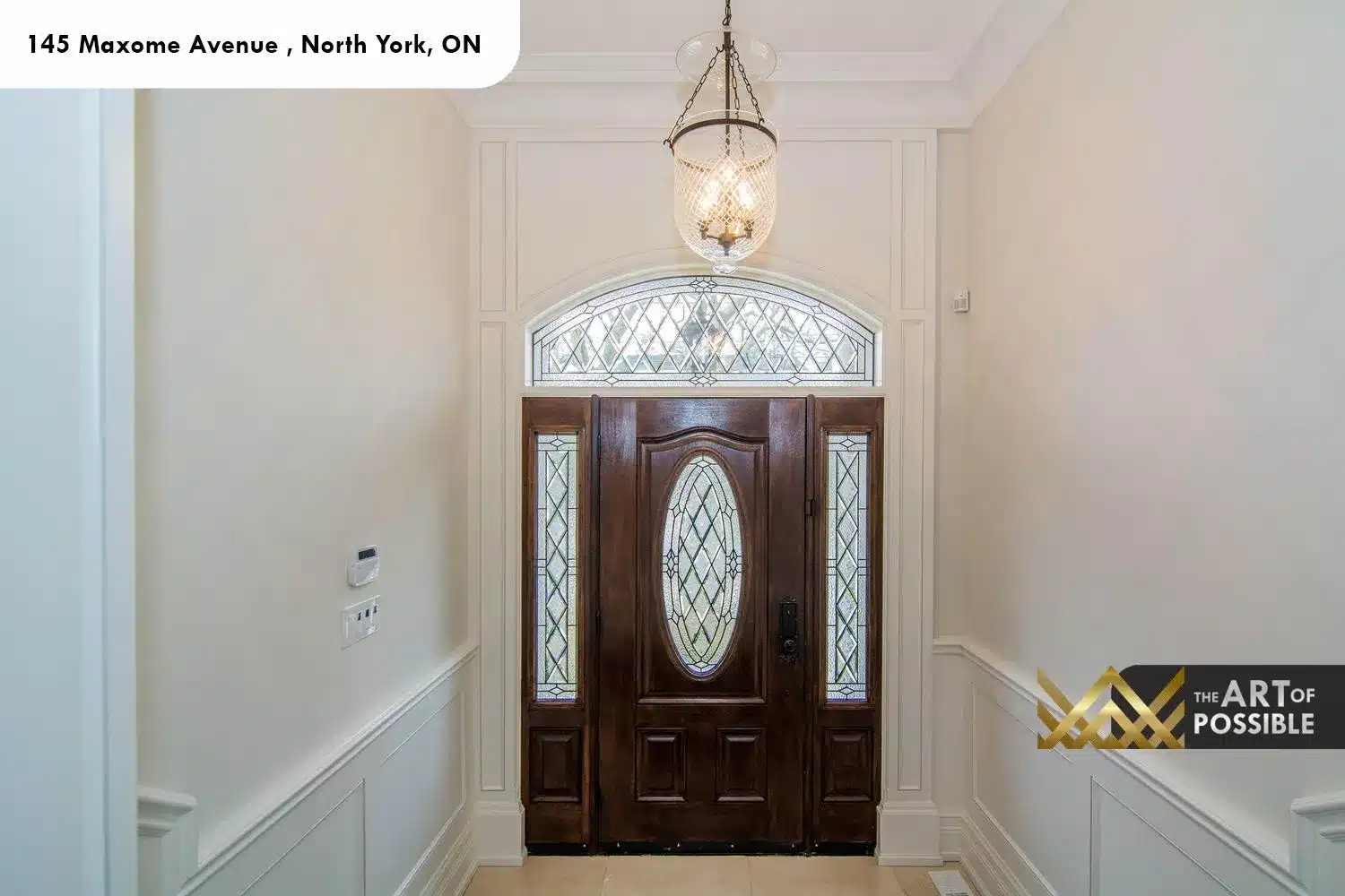 145 Maxome Avenue entry foyer polished marble floor raised panel wainscotting arched surround crystal pendant