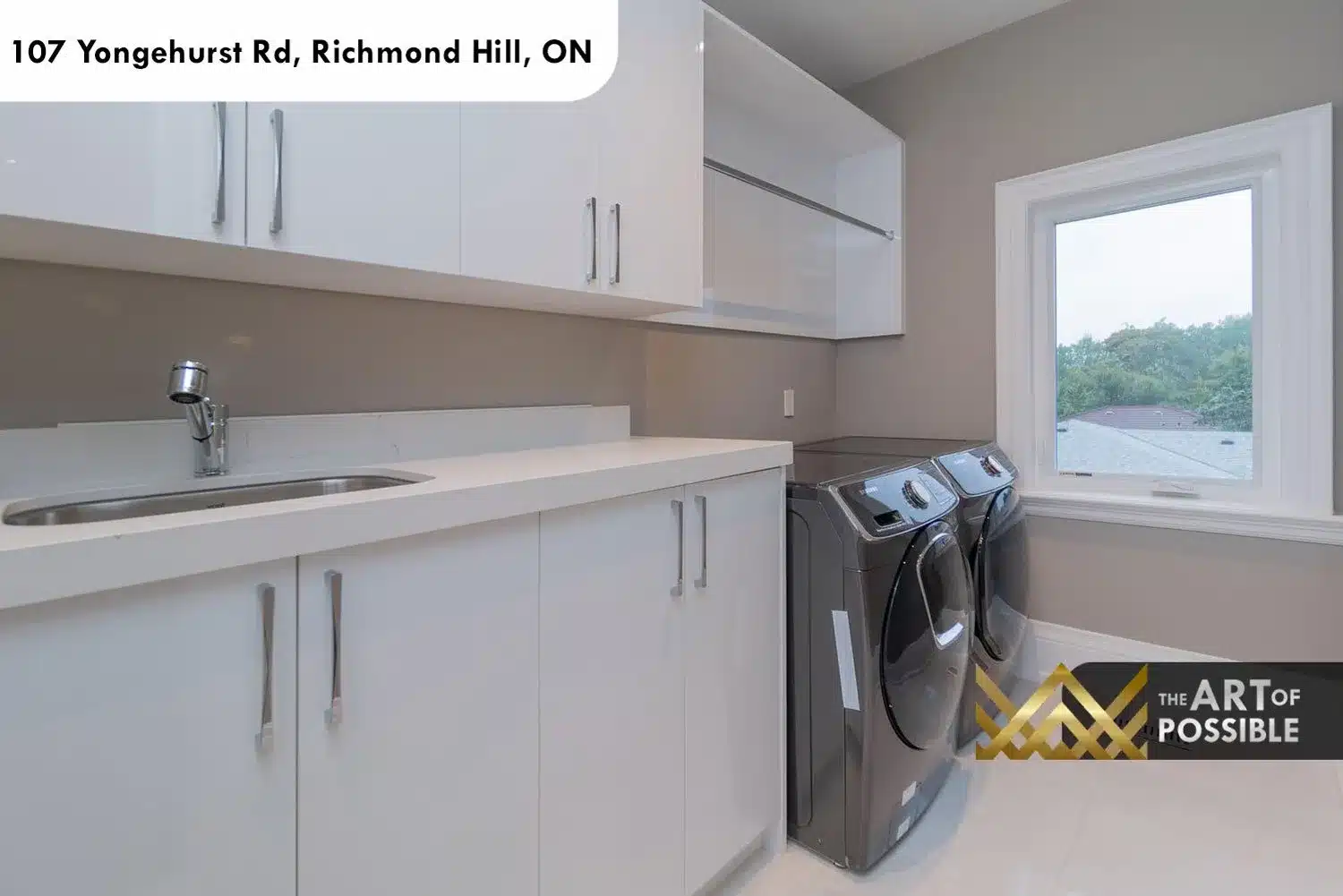 Second-floor laundry room with white gloss cabinetry, quartz counter and front-load washer and dryer