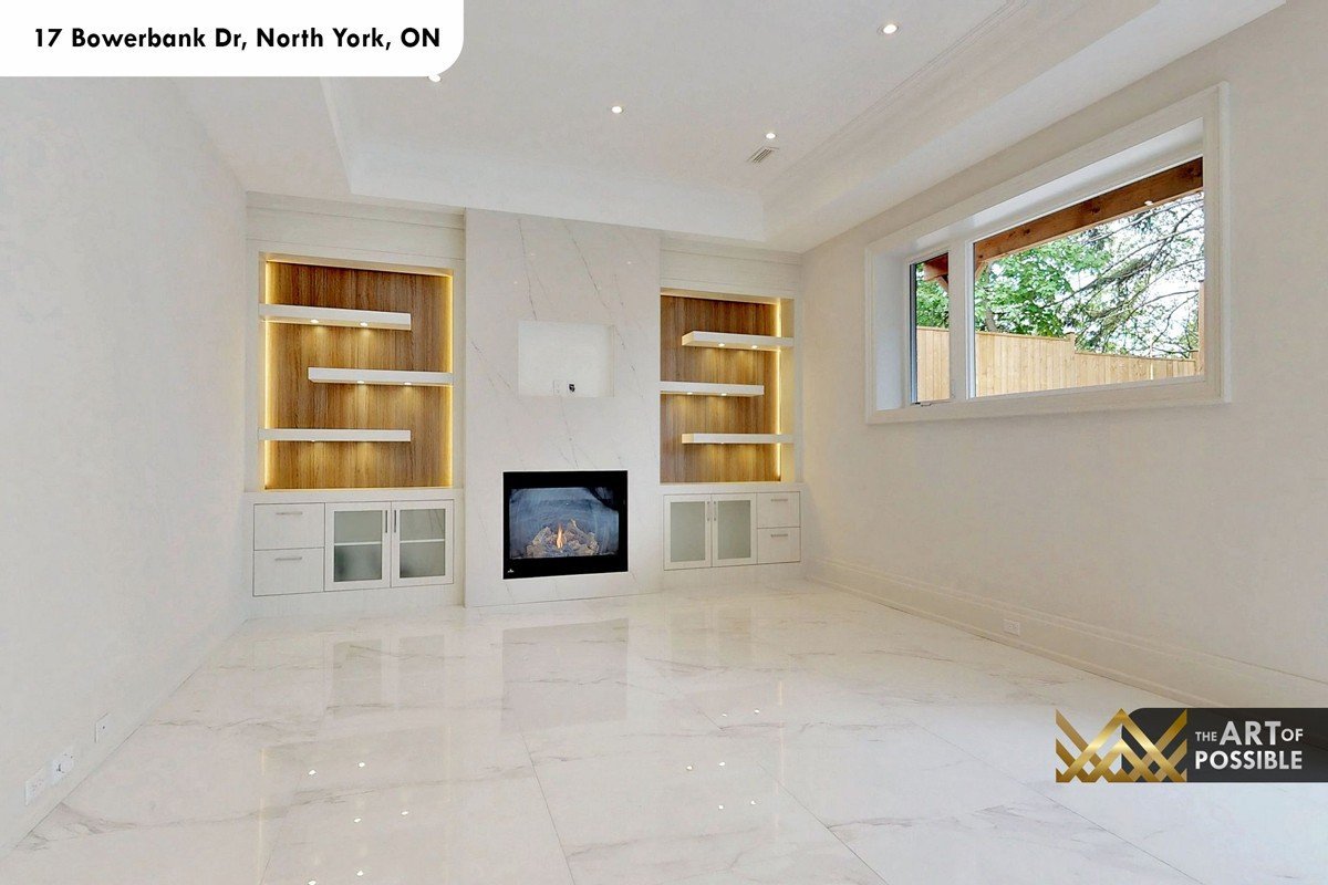 Lower level recreation room with white marble fireplace and LED-lit oak built-in shelving