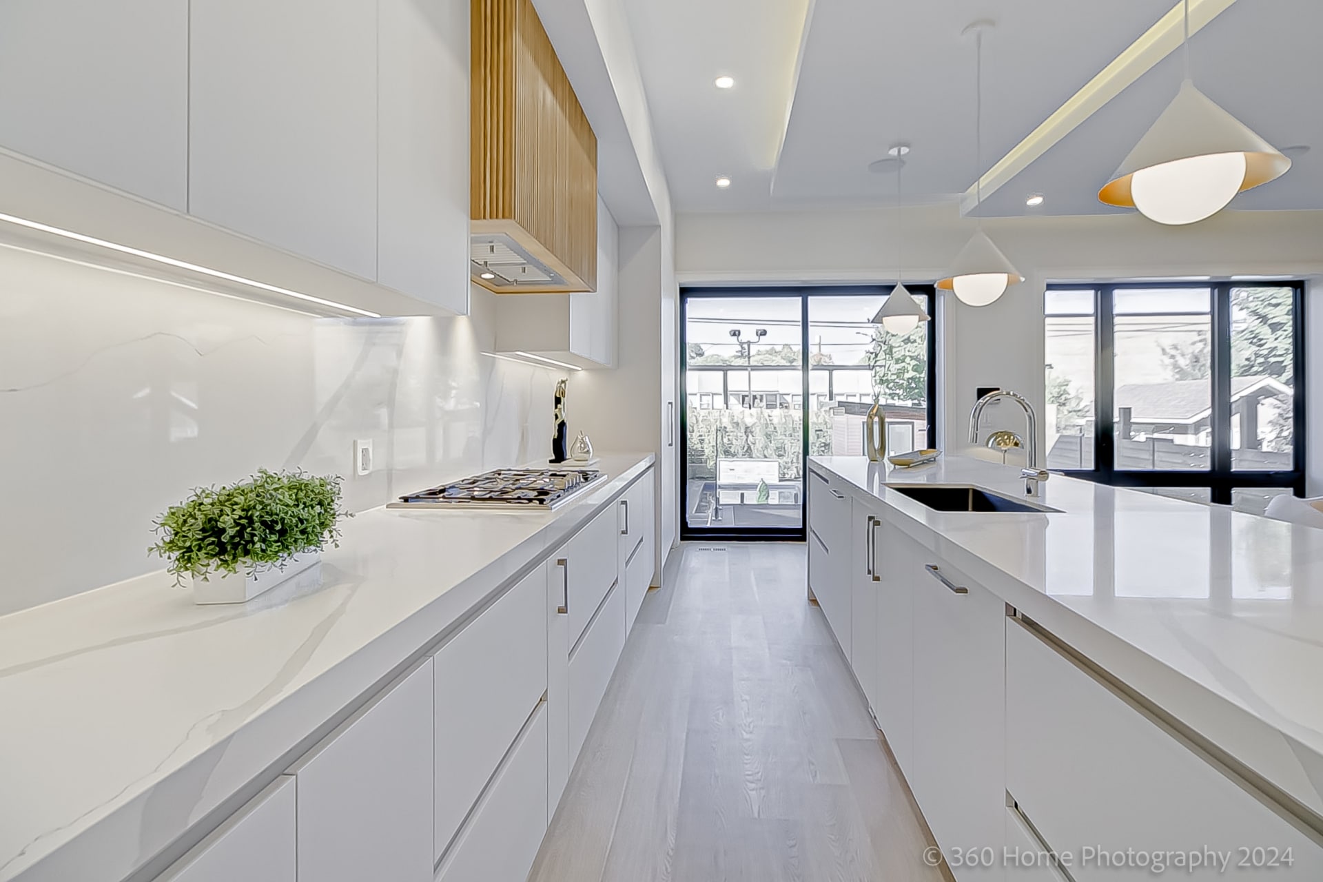 Kitchen at 100 Glenvale Blvd with white flat-front cabinetry, marble-look quartz backsplash and reeded oak island base