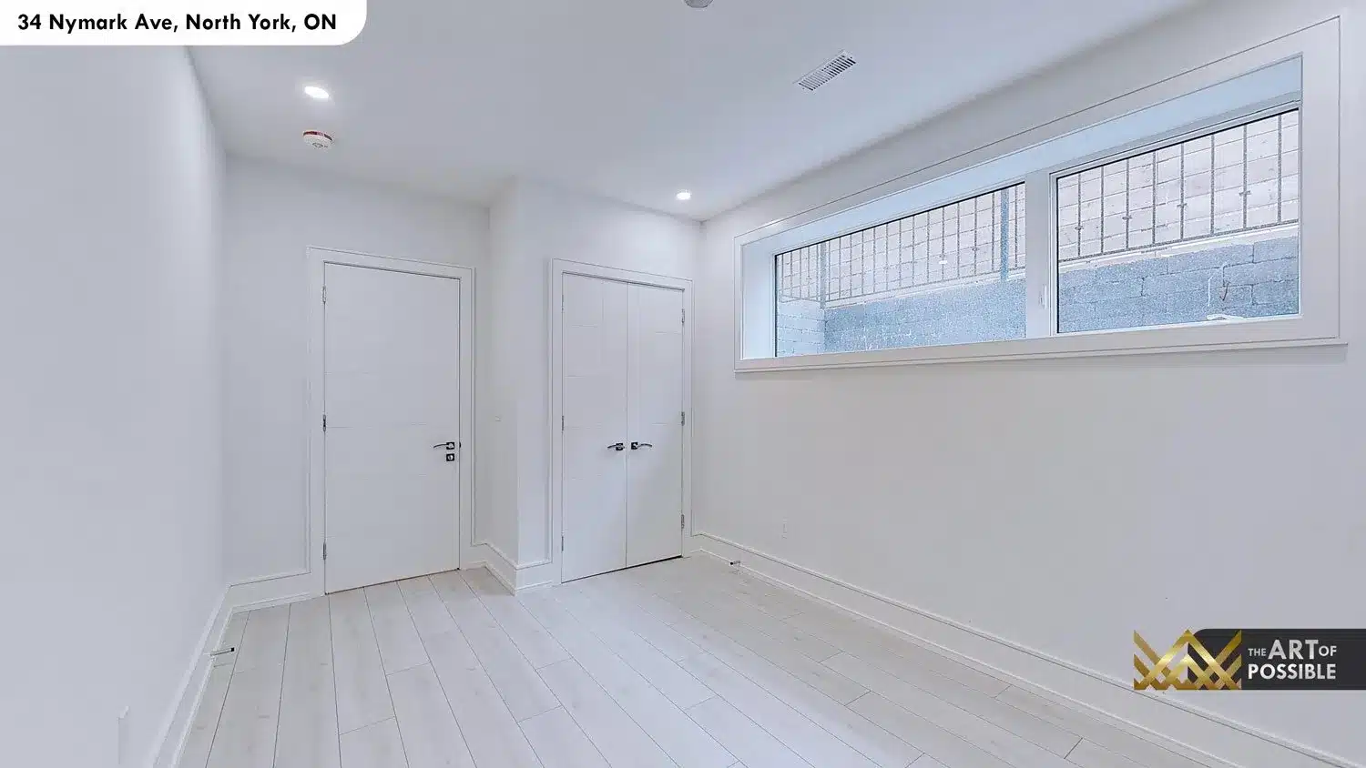 Lower level bedroom with grade-level window and double closet doors