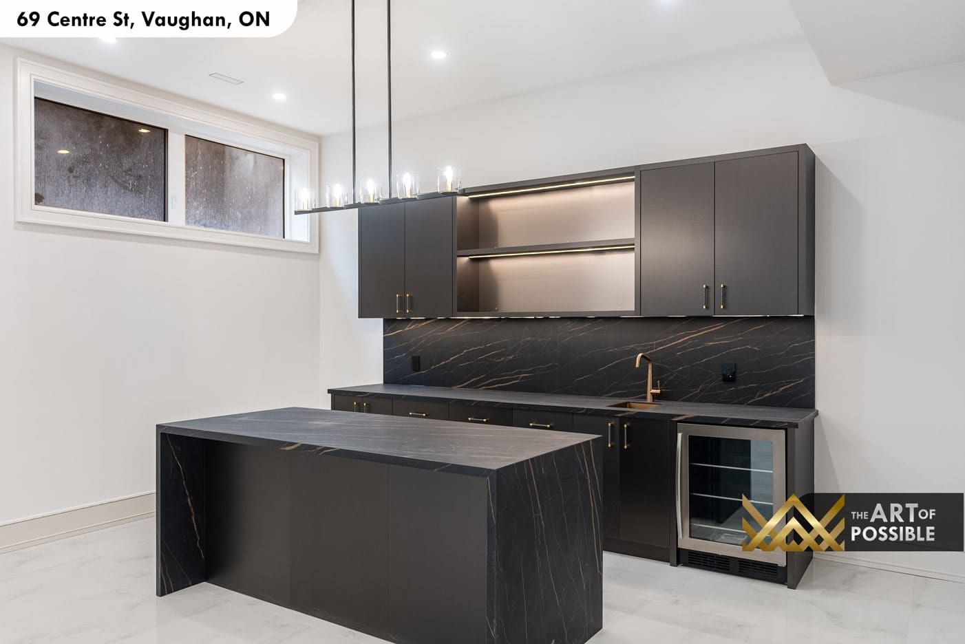 Basement wet bar with dark charcoal cabinetry, Nero Marquina slab and stone waterfall island