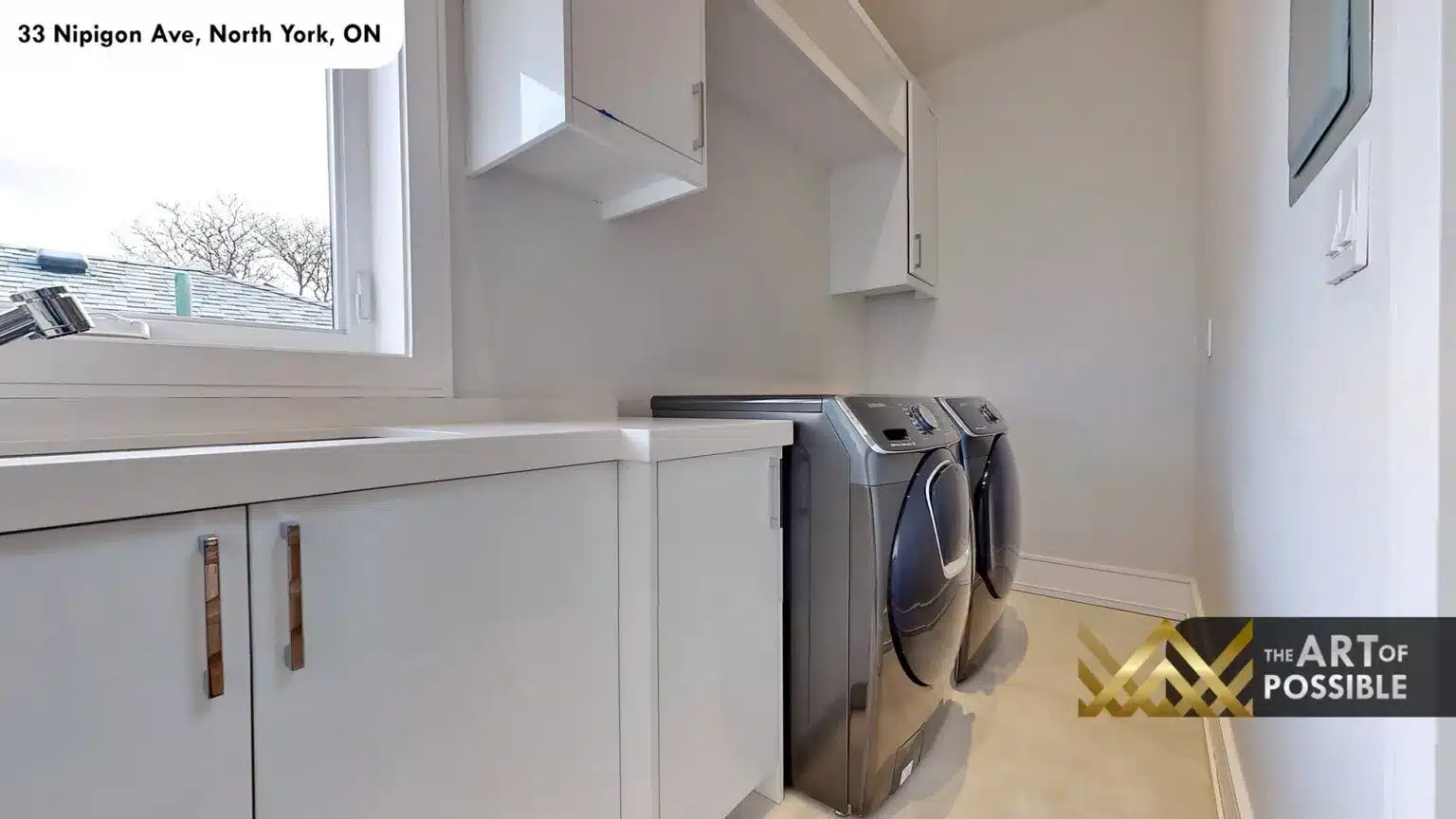 Upper floor laundry room with white cabinetry and side-by-side washer dryer
