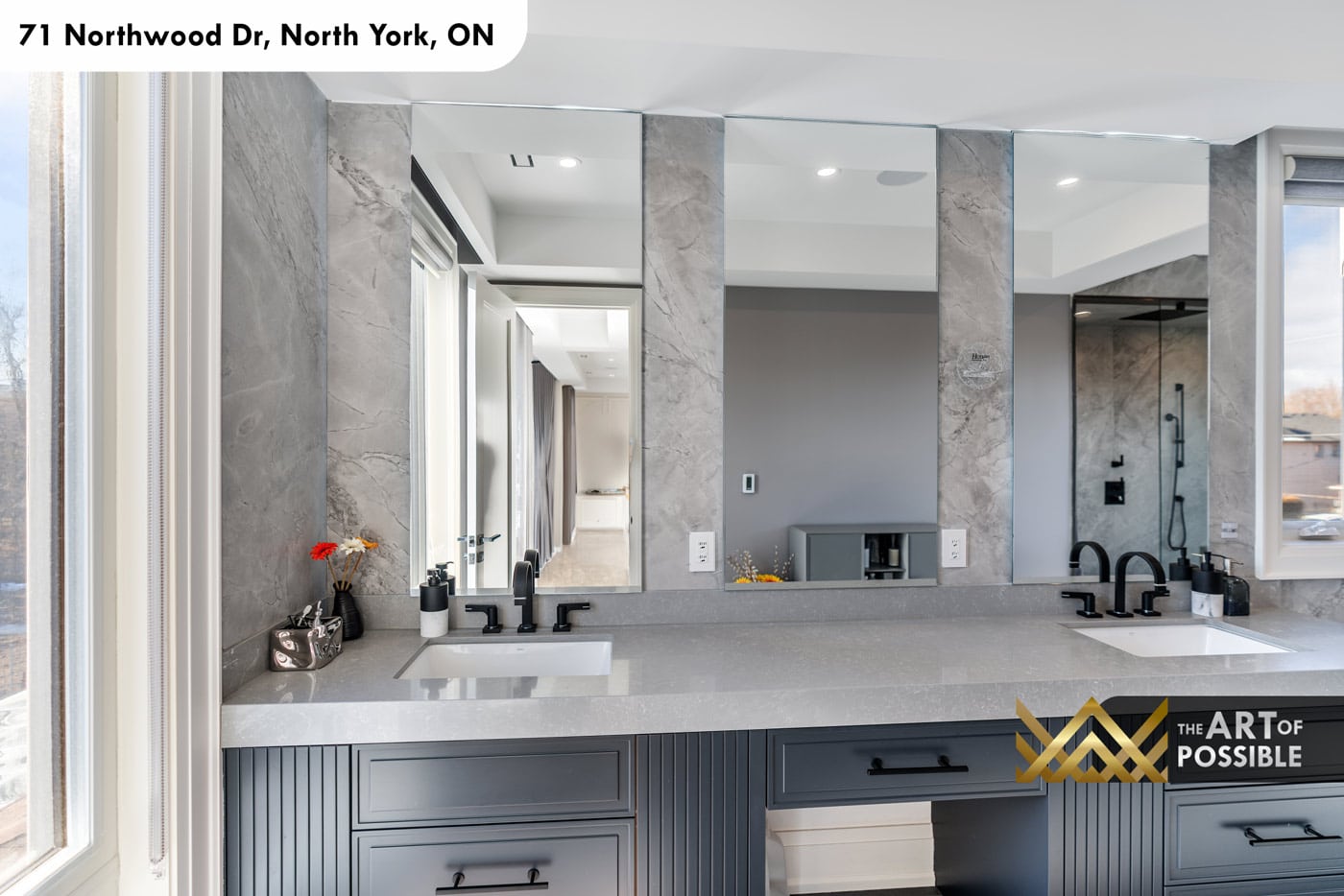 Primary ensuite double vanity detail with grey fluted cabinet, three-panel mirror and matte black faucets