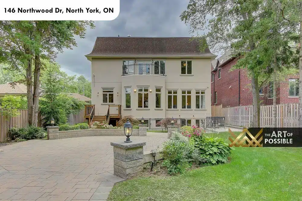 Rear elevation of 146 Northwood Dr with stone patio and garden beds