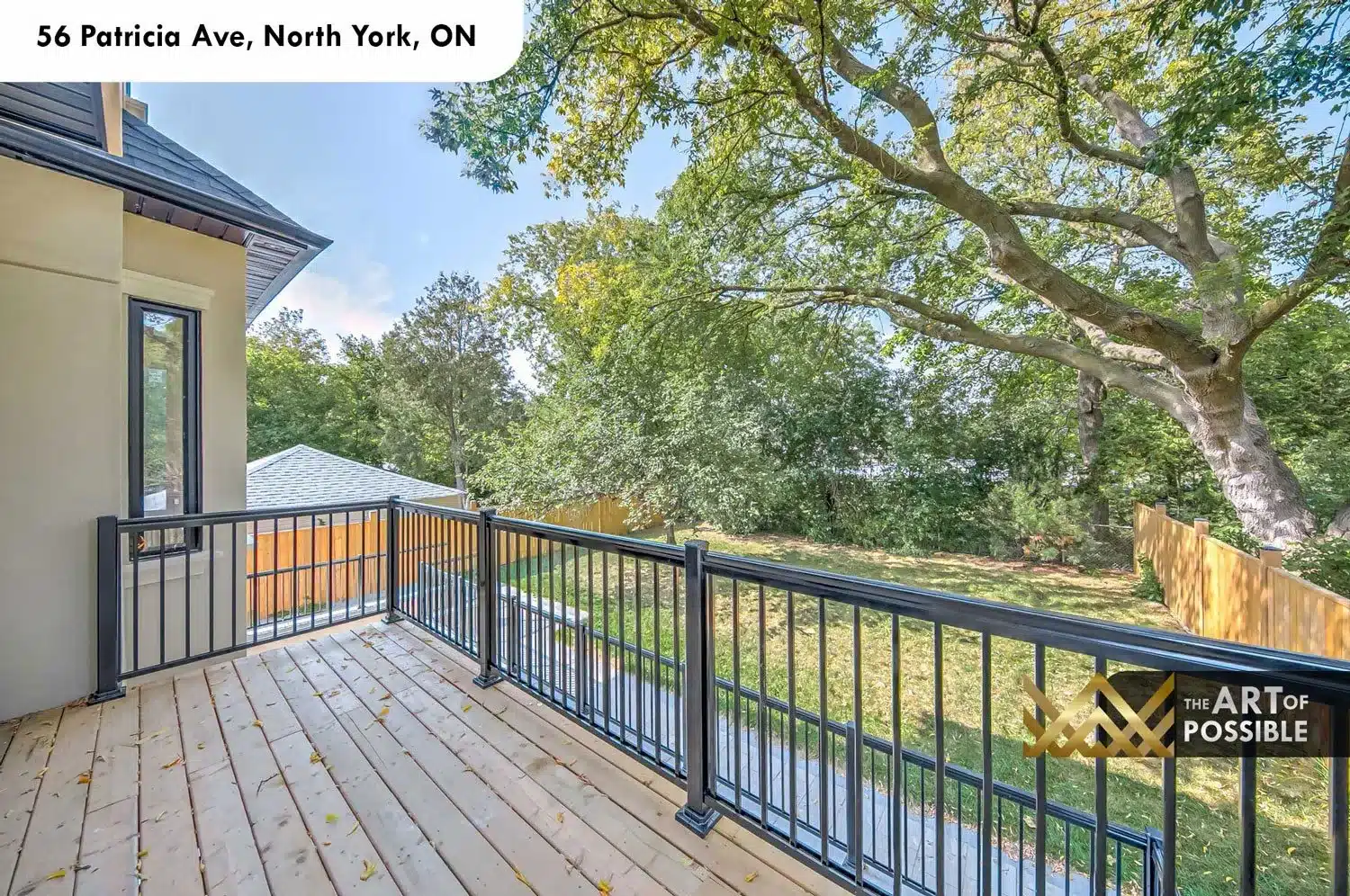 Rear deck at 56 Patricia Ave with black metal railings and treetop views