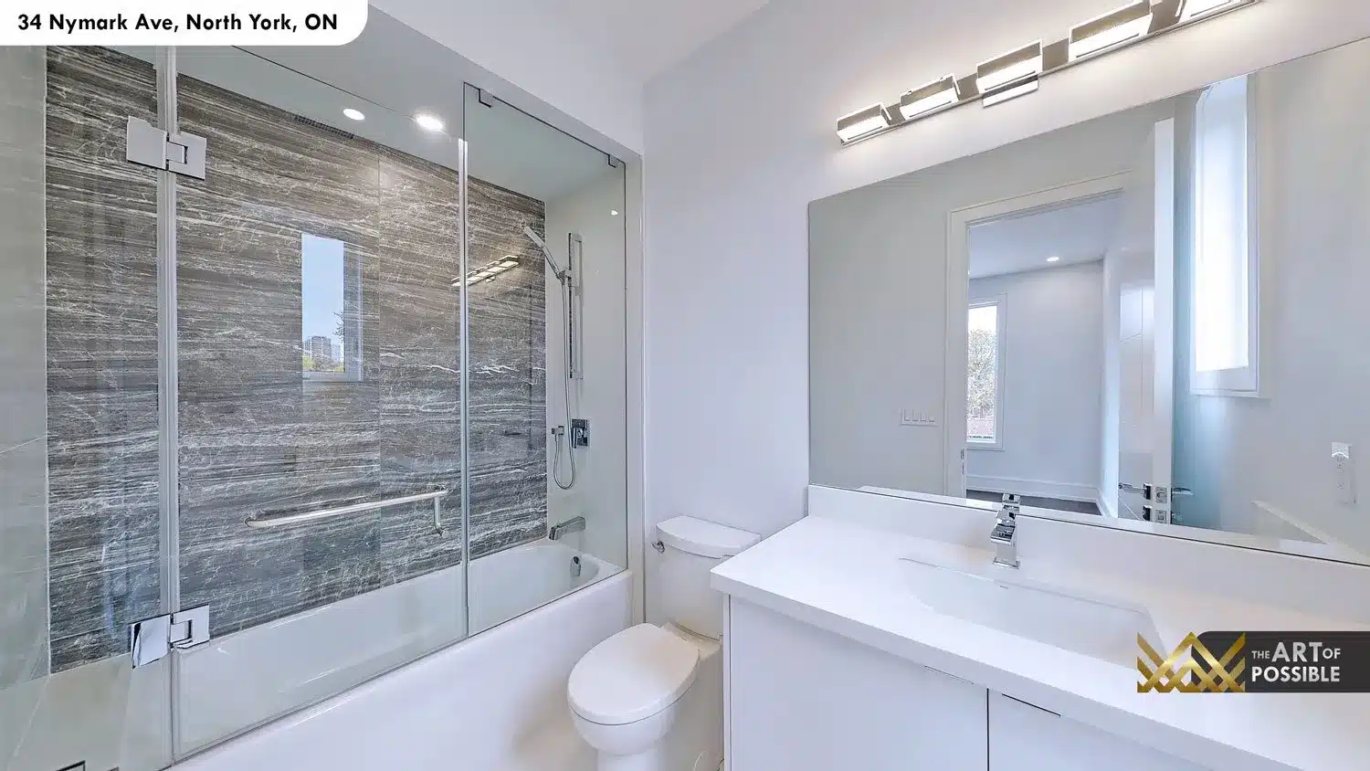 Secondary bathroom - frameless glass tub and shower combo with large-format dark grey striated stone tile surround