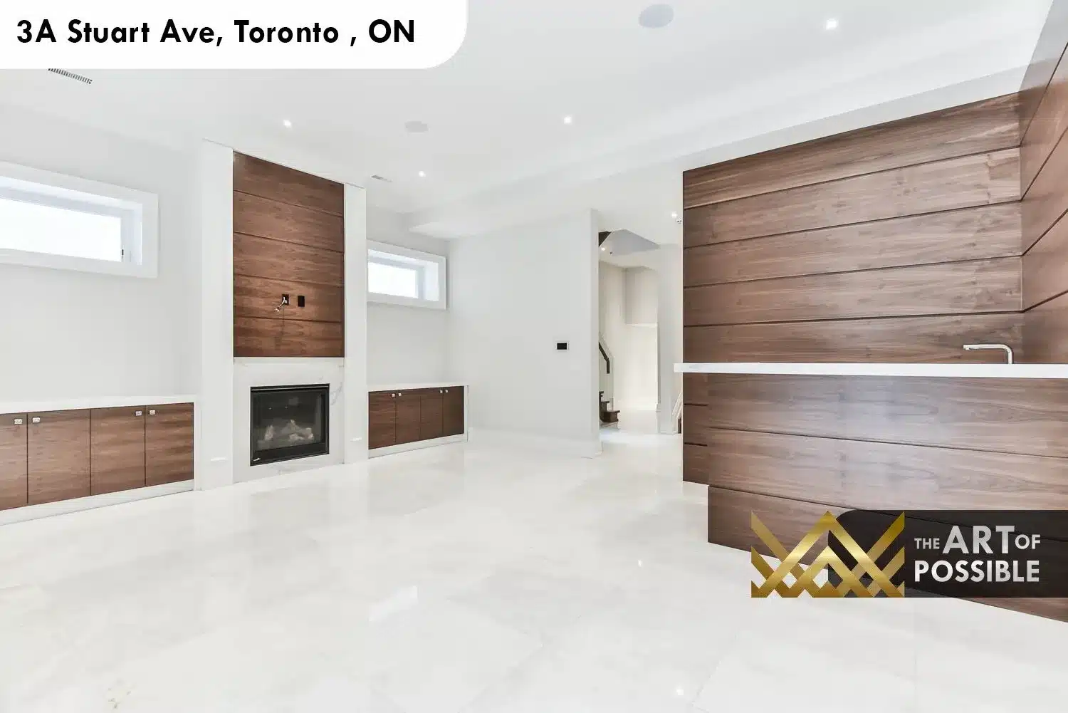 Lower level recreation room at 3A Stuart Ave with walnut feature walls flanking fireplace and polished tile floors