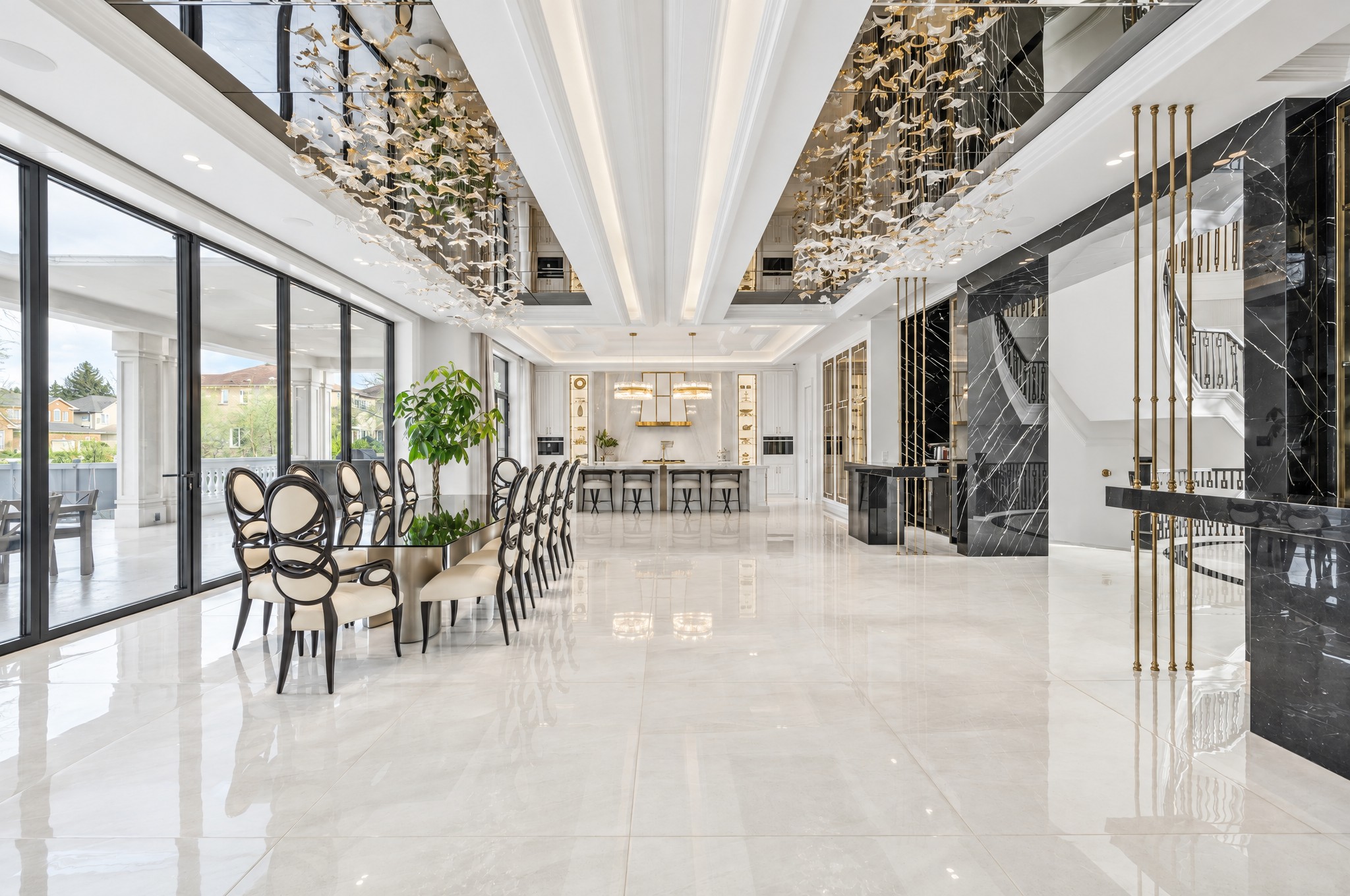 Open main floor with formal dining table, mirrored ceiling recesses and gold leaf chandeliers
