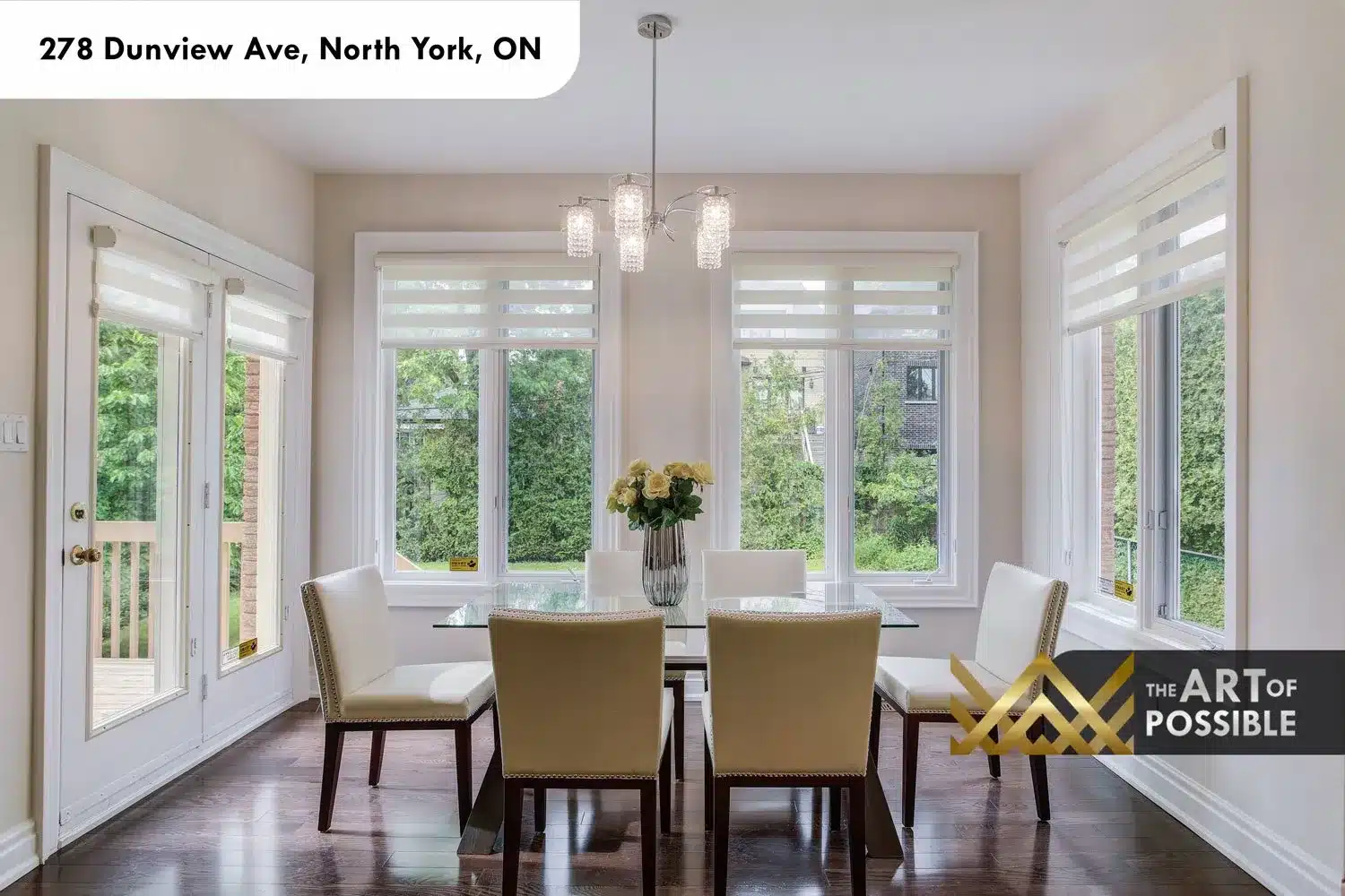 Breakfast area with crystal pendant light, glass dining table and walk-out to rear deck