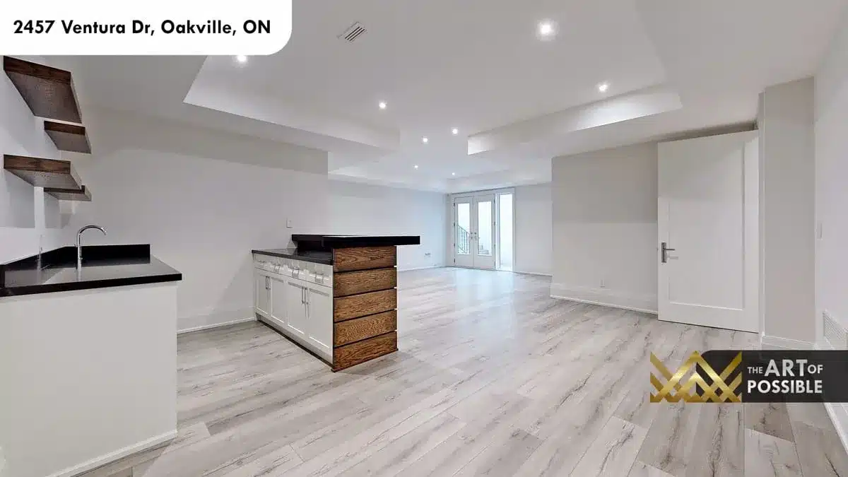 Lower level recreation room with wood-clad wet bar French doors to walkout backyard at 2457 Ventura Dr Oakville