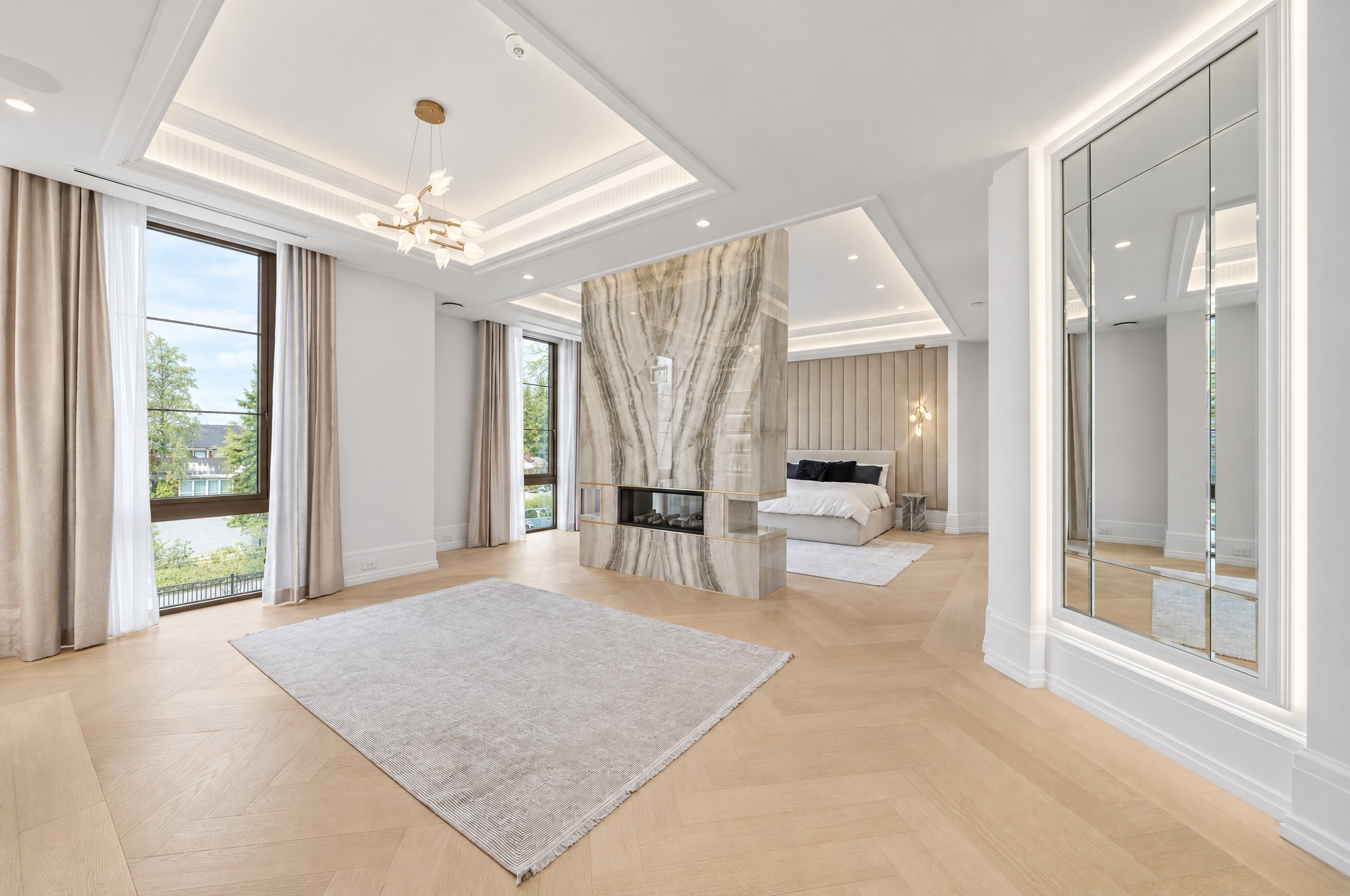 Primary suite sitting area with a see-through fireplace in a banded stone column